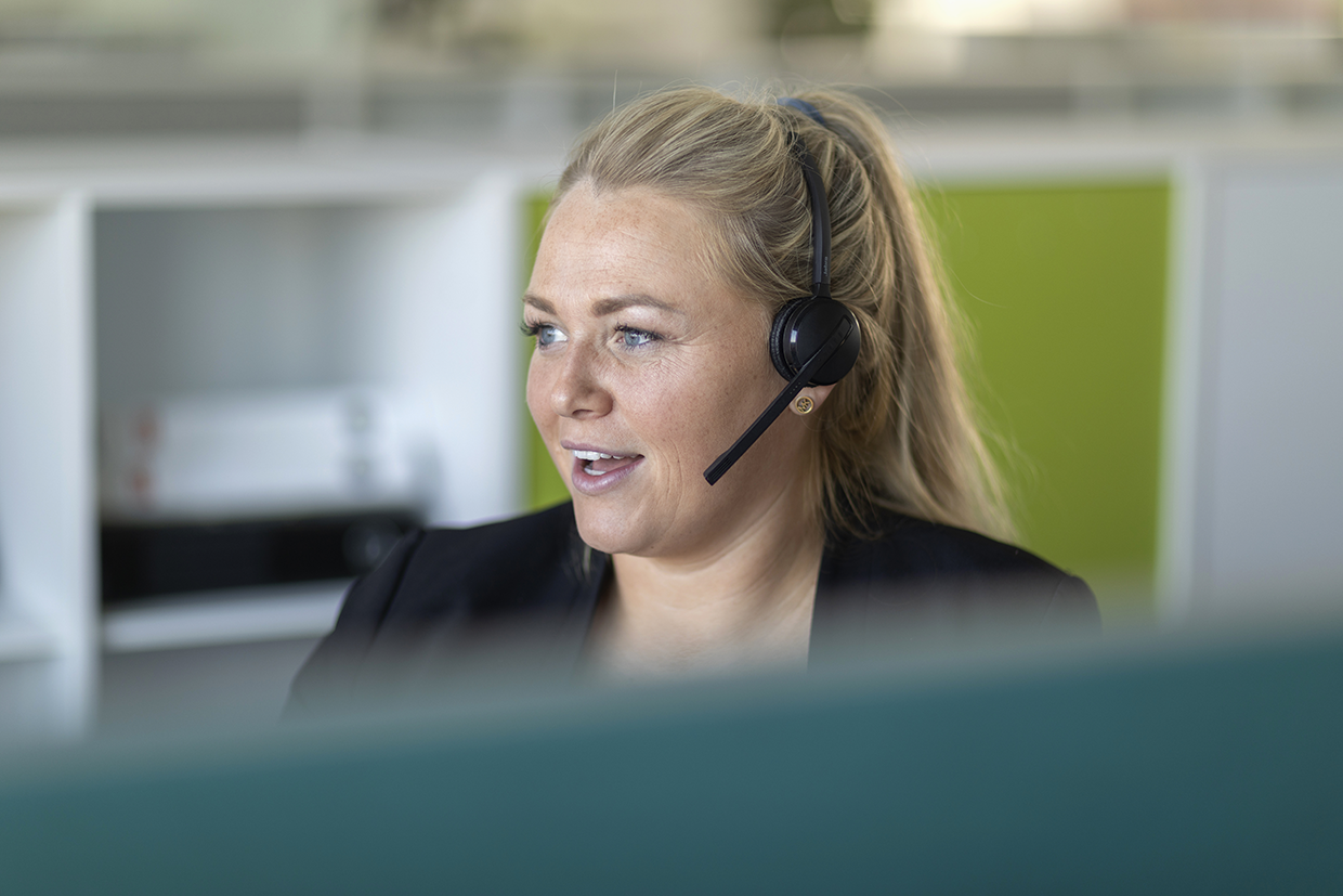 kvinde med headset på arbejdeplads